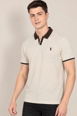 Model wearing an oatmeal short-sleeve polo with dark contrast collar and cuffs, front view