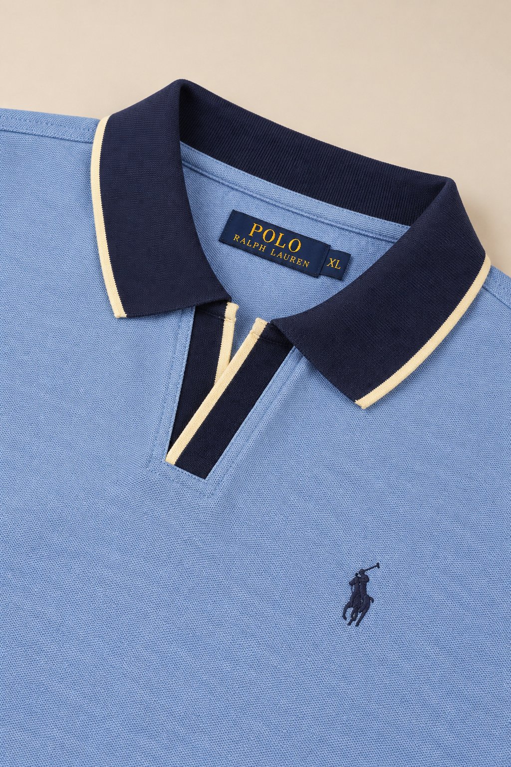 Close-up of the navy contrast collar on a heather blue polo shirt